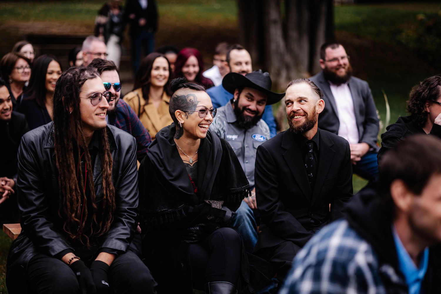 A candid moment from an alternative wedding in Southern Ontario, with stylish tattooed guests laughing during the ceremony. This image captures the authenticity and joy that defines modern Southern Ontario wedding photography.