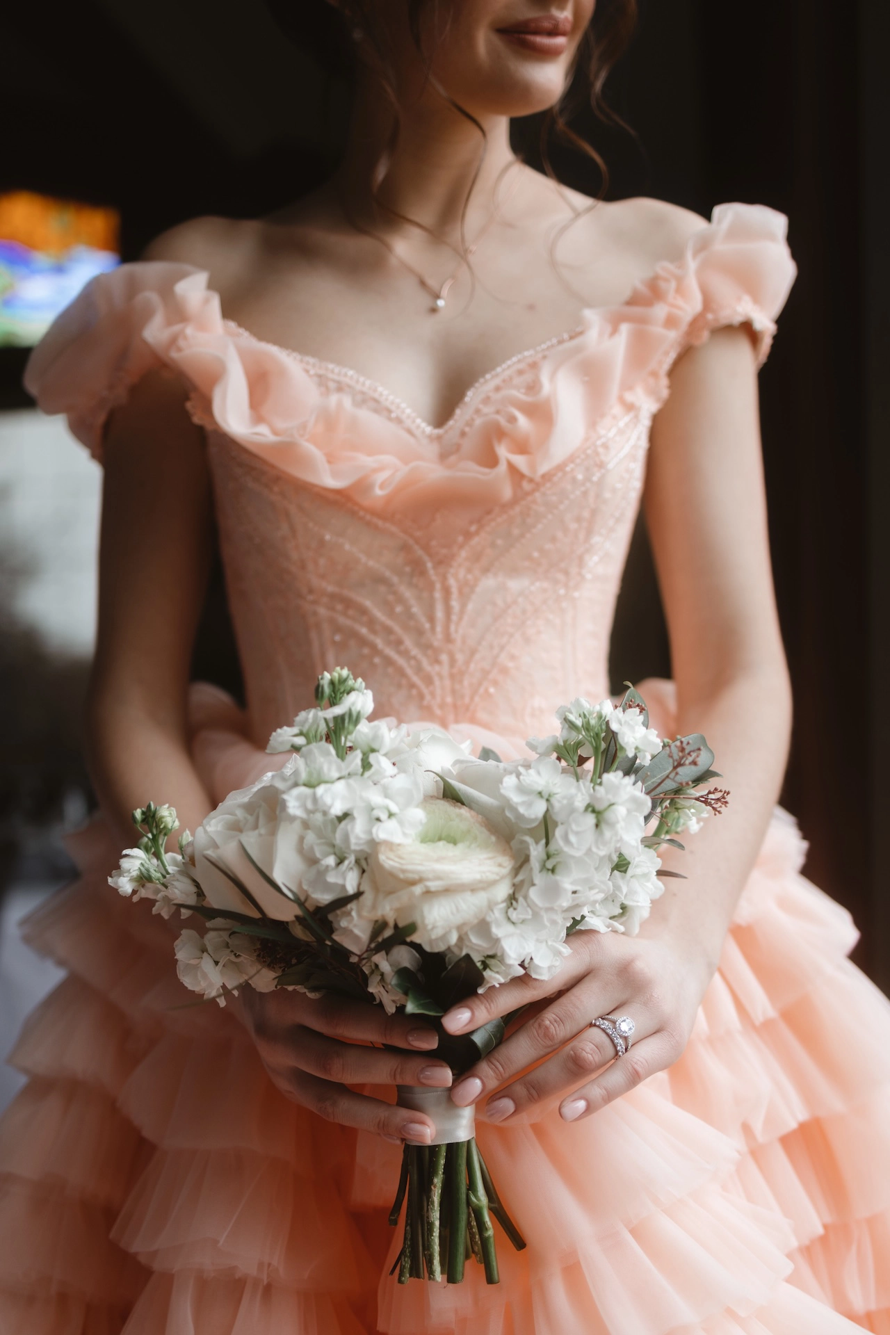 A romantic bridal bouquet captured as the bride poses in a soft peach wedding dress. A dreamy detail from Southern Ontario wedding photography.