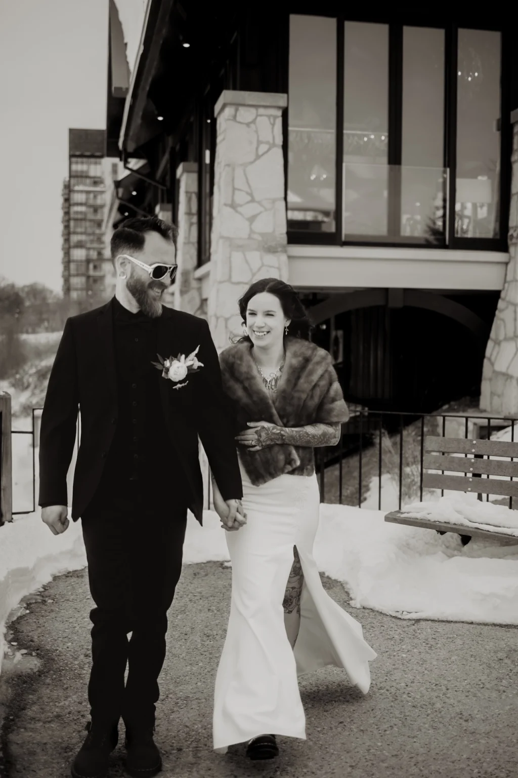 Couple walking outside Cambridge Mill wedding venue in a black and white photo Title: cambridge-mill-best-wedding-locations
