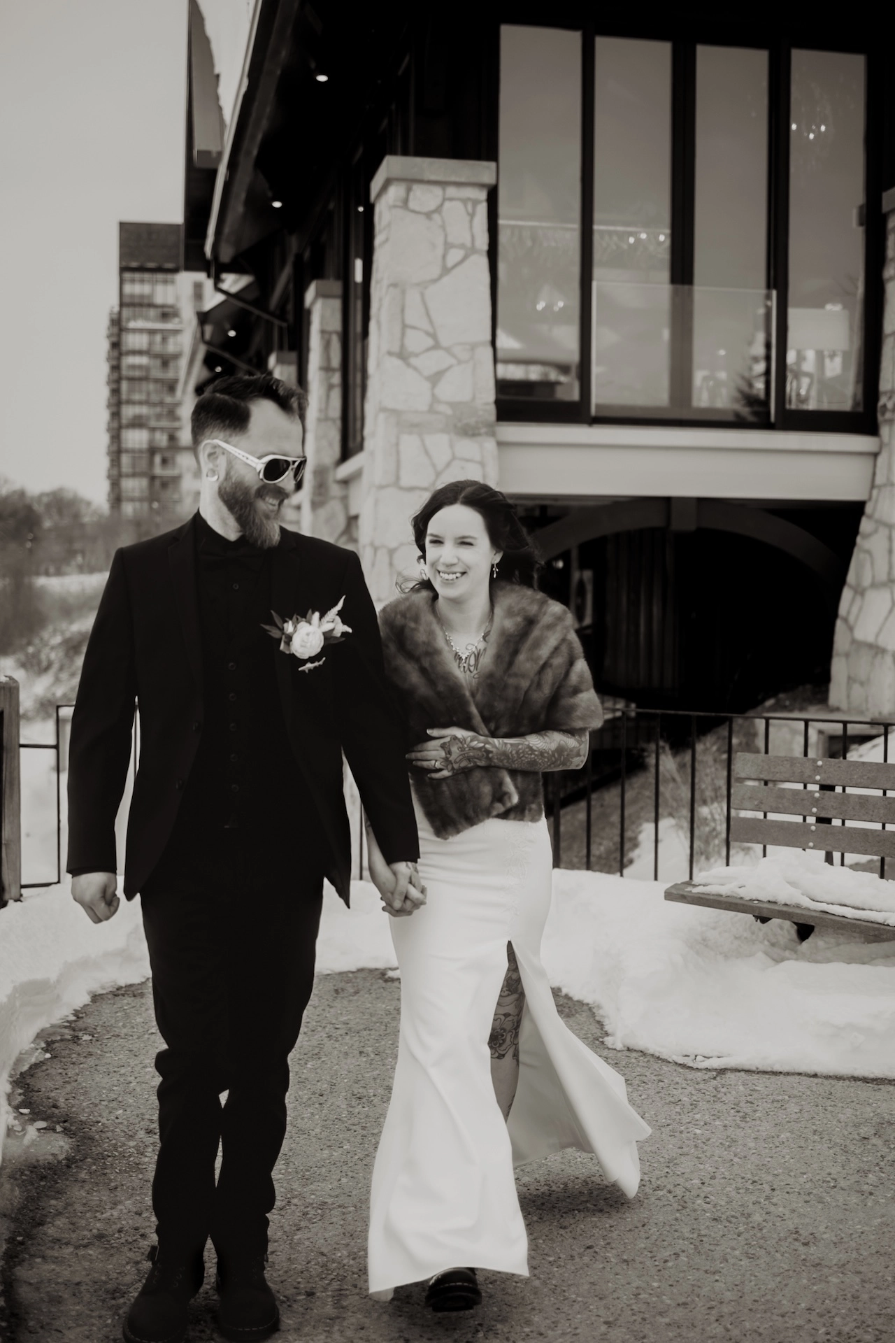 Elegant black and white photo of a couple walking outside Cambridge Mill, one of the best wedding locations near Brantford and Southern Ontario.