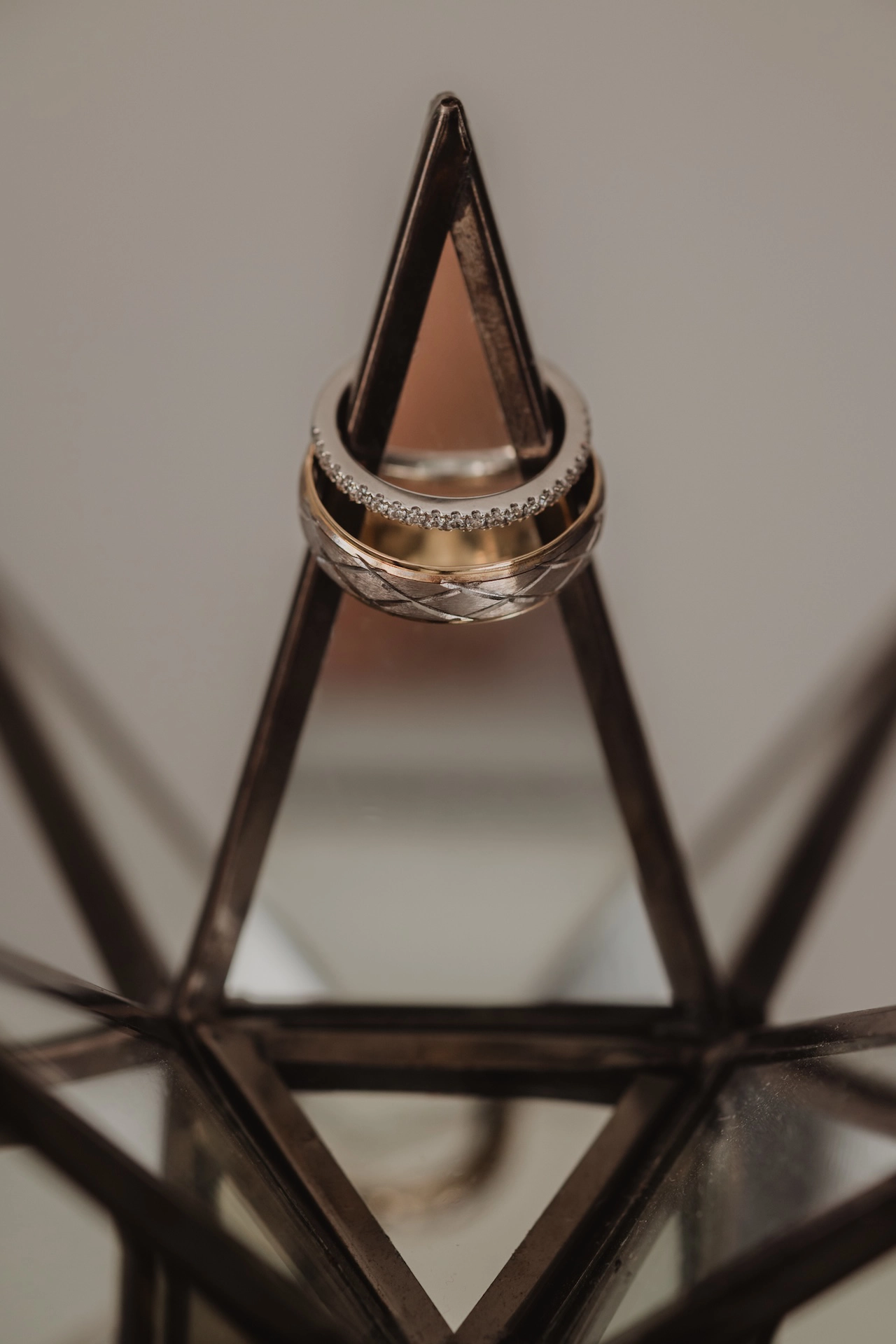 Artistic photo of wedding rings styled on a geometric glass surface, adding a modern touch to a Southern Ontario wedding story.