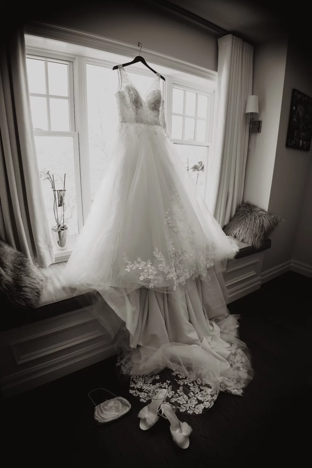 Black and white shot of dress on the bride's bedroom window.