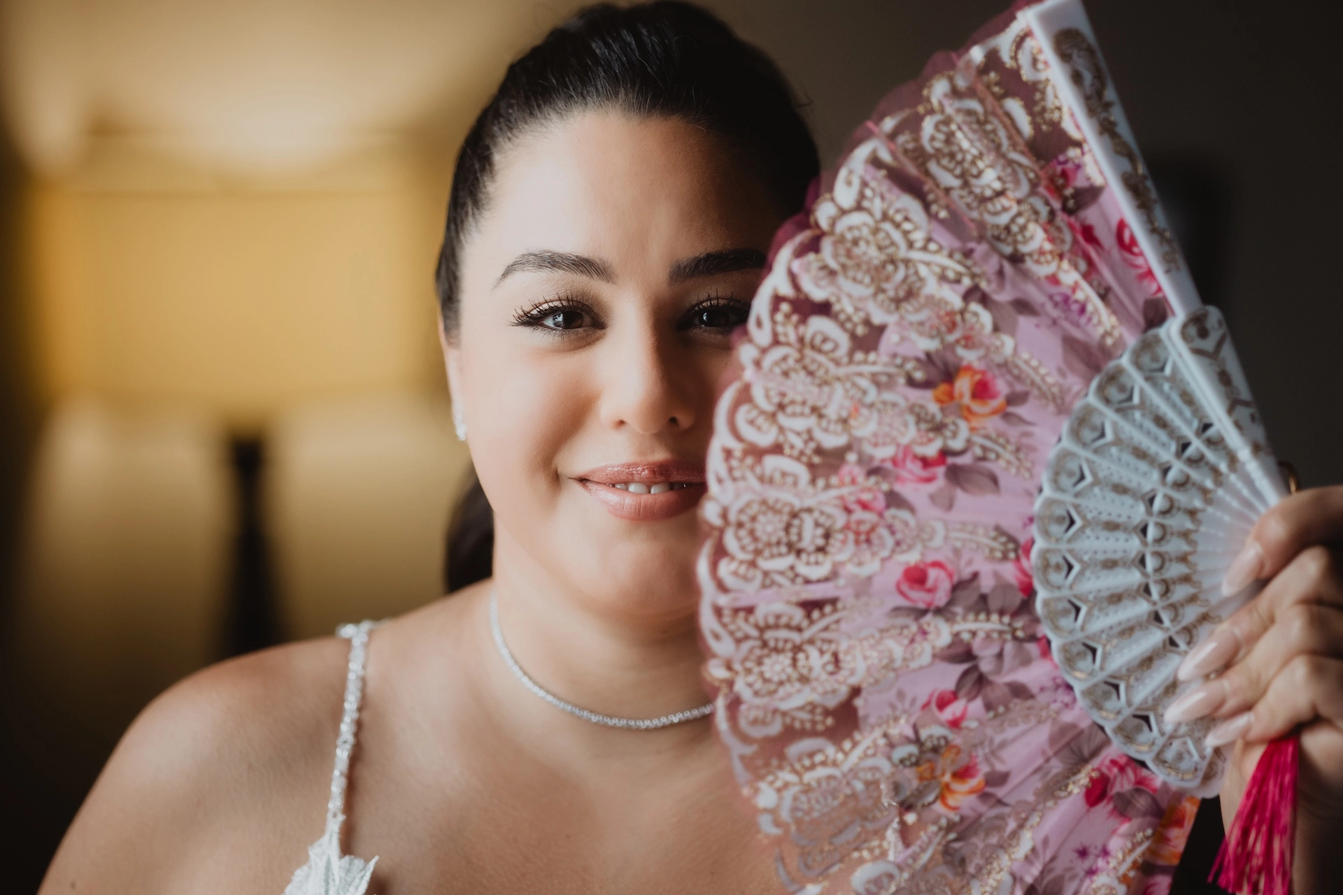 A joyful close-up of the bride playfully hiding behind a fan, captured by Brantford wedding photographer Alissa Baltazar, serving couples throughout Southern Ontario including Hamilton and Cambridge.
