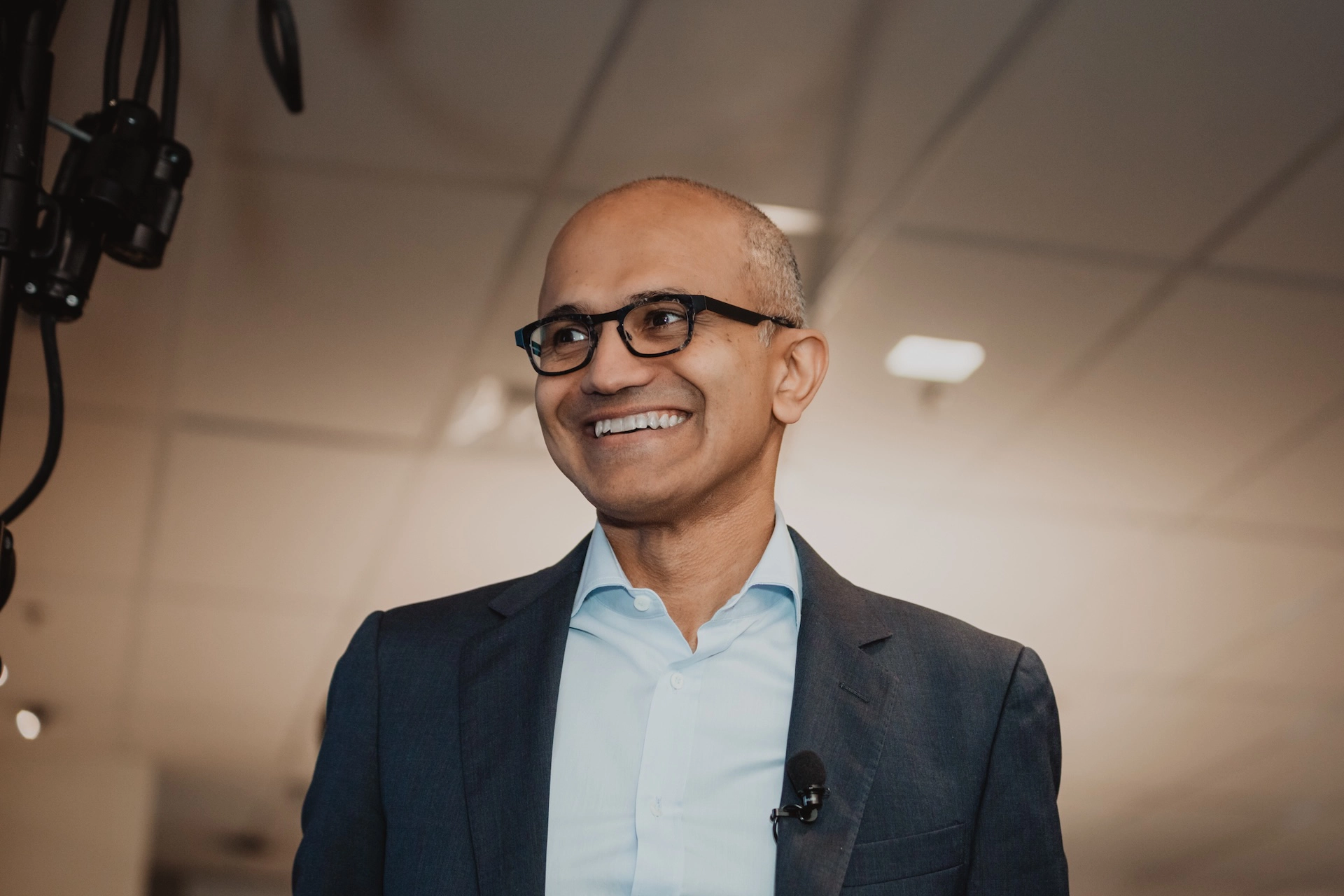 A candid close-up of Microsoft CEO Satya Nadella sharing a warm, genuine smile during a public event—capturing leadership in an authentic light.