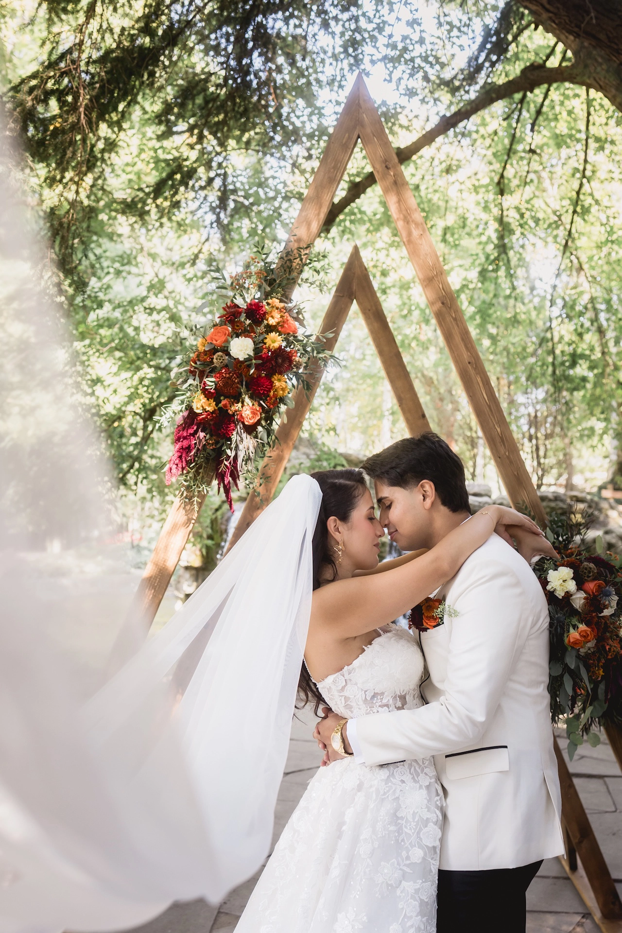 A beautiful moment captured outdoors of a couple sharing a kiss with the veil gently flowing, photographed by Brantford wedding photographer Alissa Baltazar.