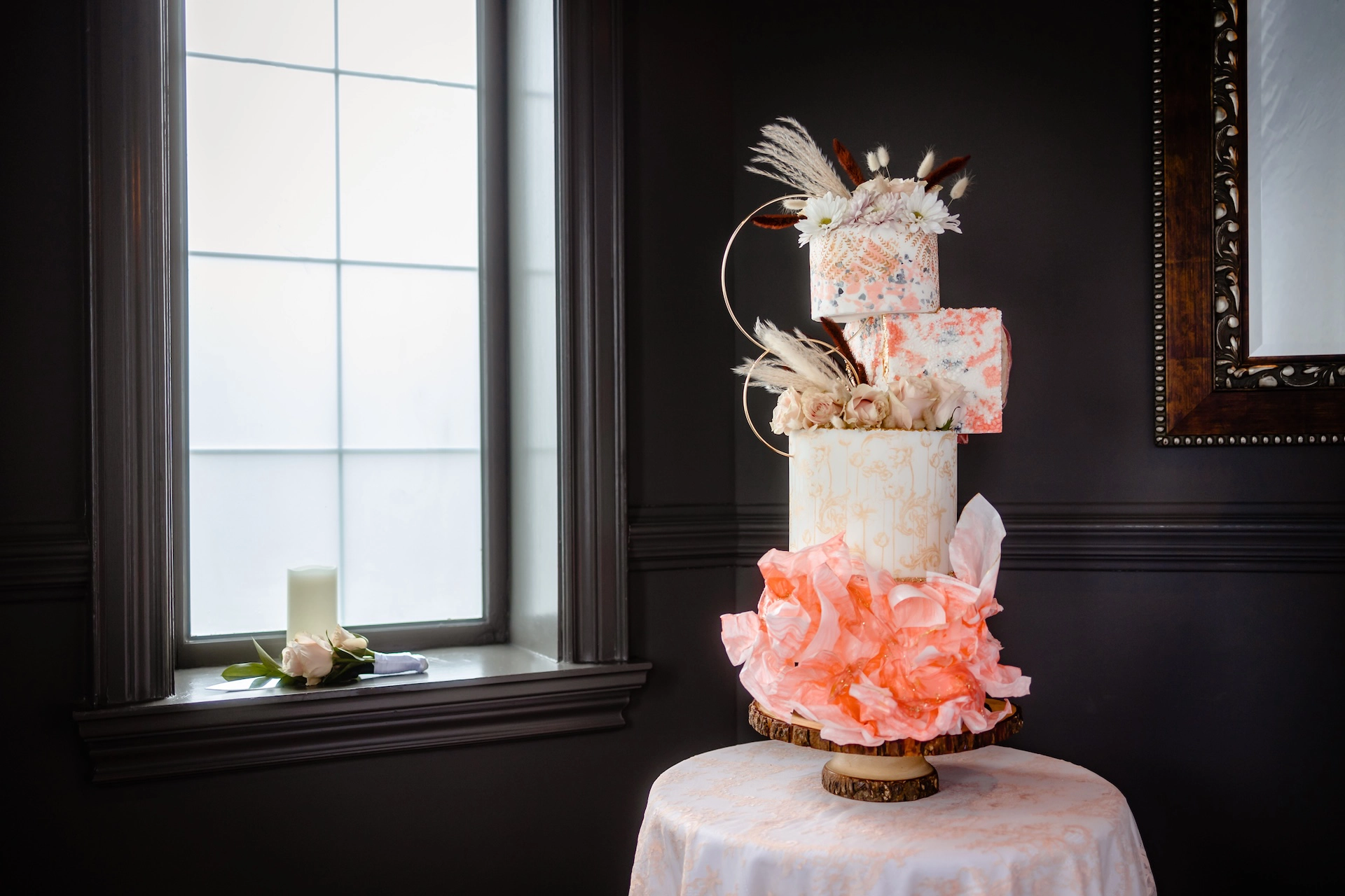 Striking bold pink avant-garde wedding cake beautifully displayed next to a window, captured by Brantford wedding photographer Alissa Baltazar, serving Southern Ontario couples.
