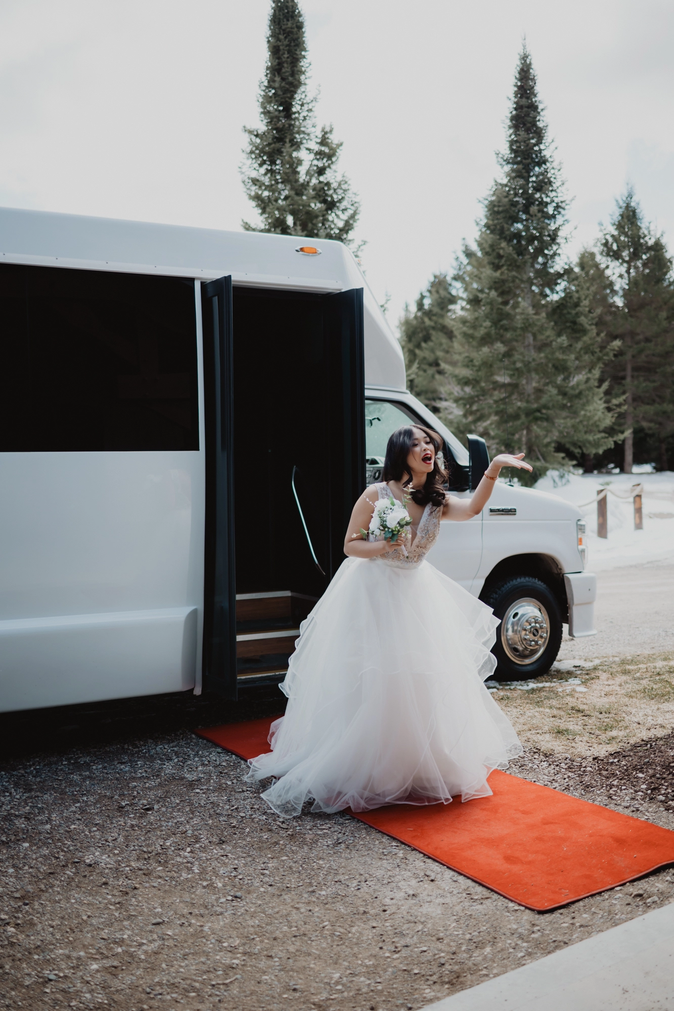 A stunning bride steps gracefully out of a limo, blowing kisses to her loved ones, captured in a beautiful Southern Ontario wedding by Alissa Baltazar.
