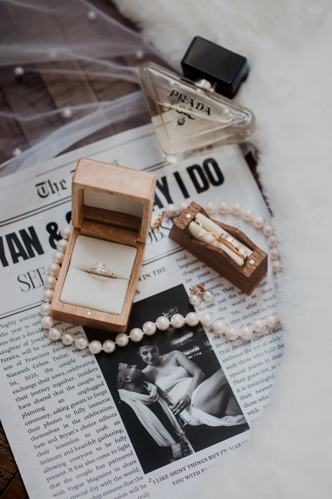 Creative shot of wedding rings and jewelry artfully arranged on a newspaper featuring the couple’s engagement picture, captured by Brantford wedding photographer Alissa Baltazar.