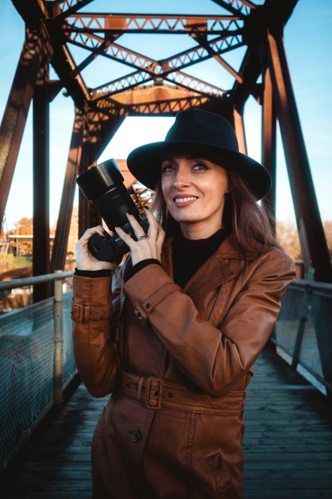 Alissa Baltazar, Brantford wedding photographer, holding a camera and capturing artistic, cinematic love stories.
