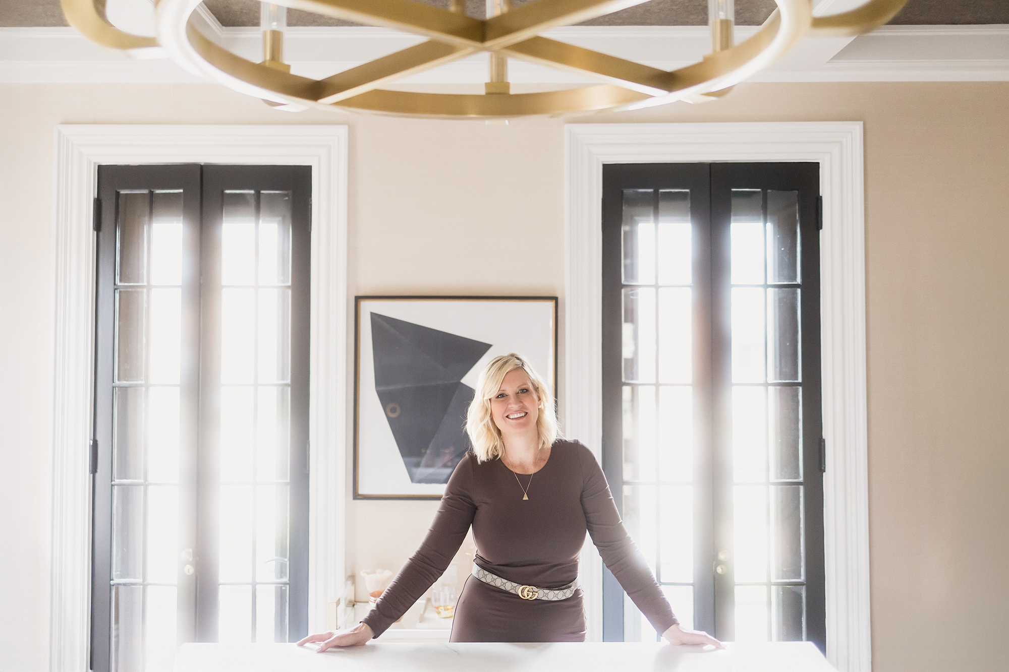 Sarah from Sarah St. Amand Interior Design Inc. standing in her beautifully styled interior studio space in Brantford.