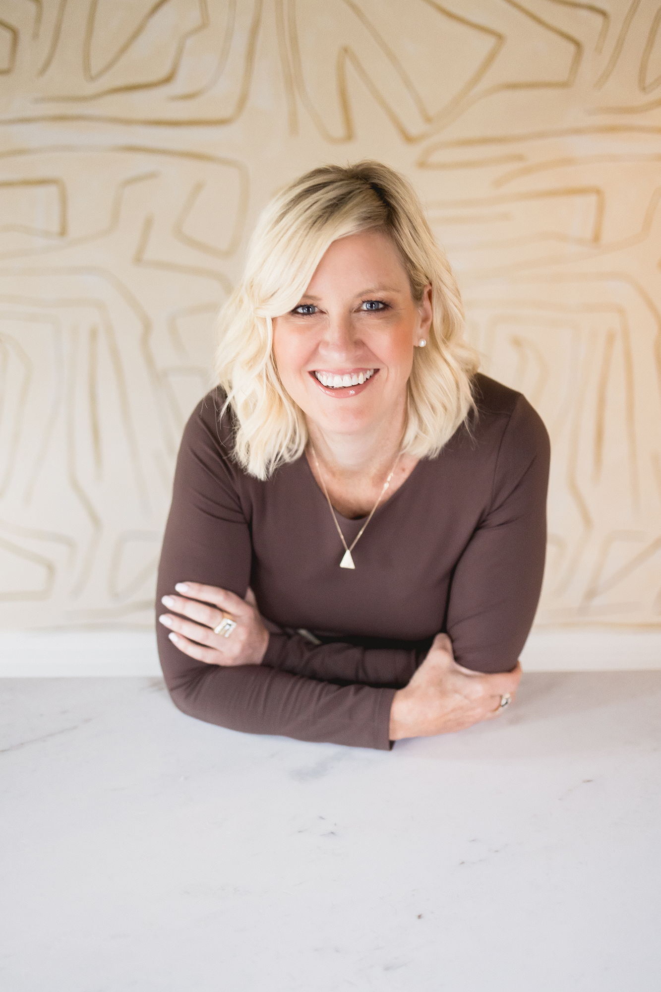 A warm, welcoming portrait of Sarah St. Amand, captured in her beautifully styled interior design studio in Brantford.