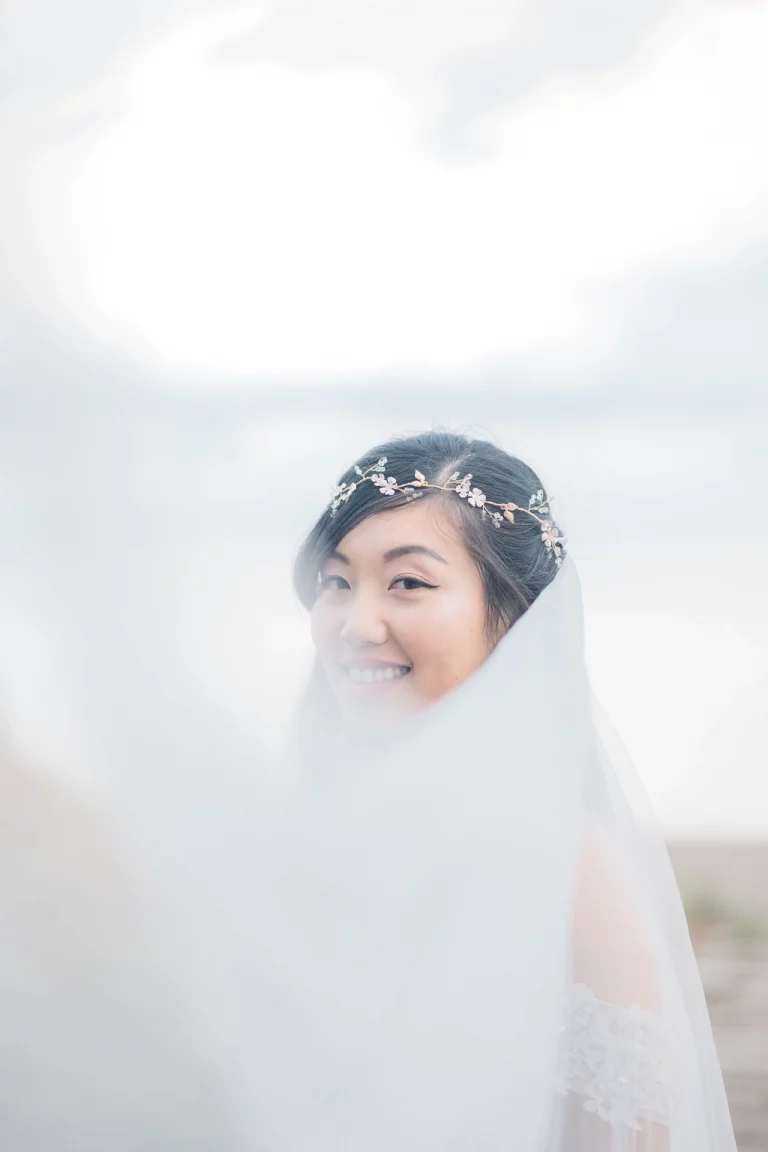 Bride with the veil across romantic portrait.