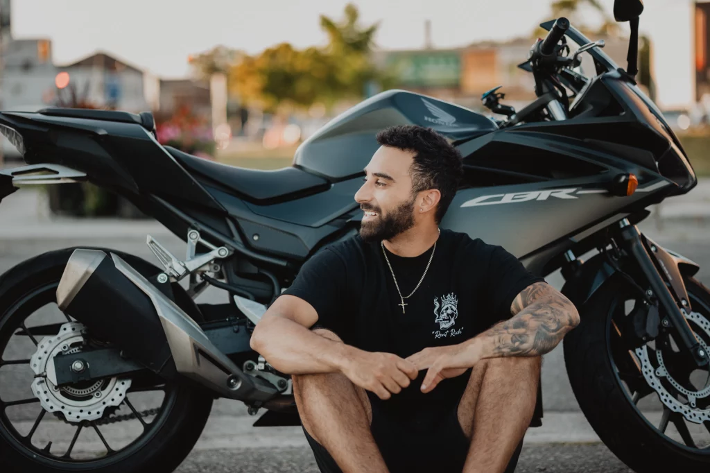 Anthony Cappucci wearing Rent Rich clothing during a branding photoshoot in downtown Brantford setting next to his motorcycle.