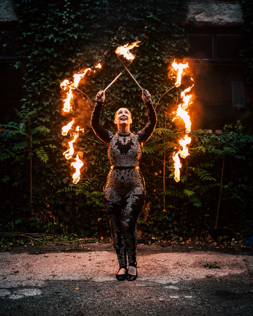 Fire performer holding a large flame during a wedding fire show, adding bold and unforgettable entertainment