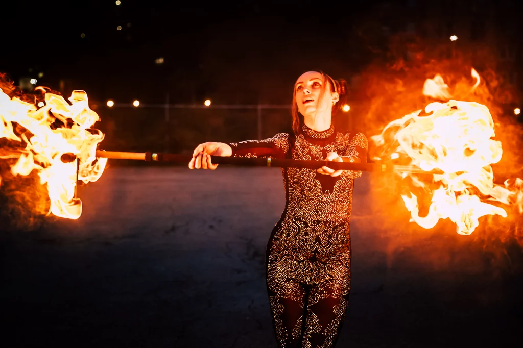 Fire dancer spinning flaming props as part of unique wedding entertainment during a fire dancing show