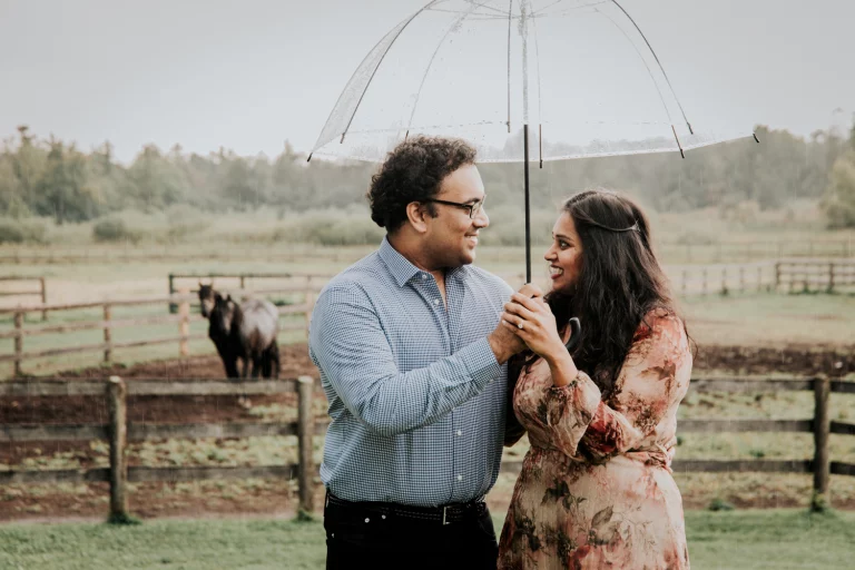 Wedding photographer photography of a couple sharing a moment in the rain under an umbrella