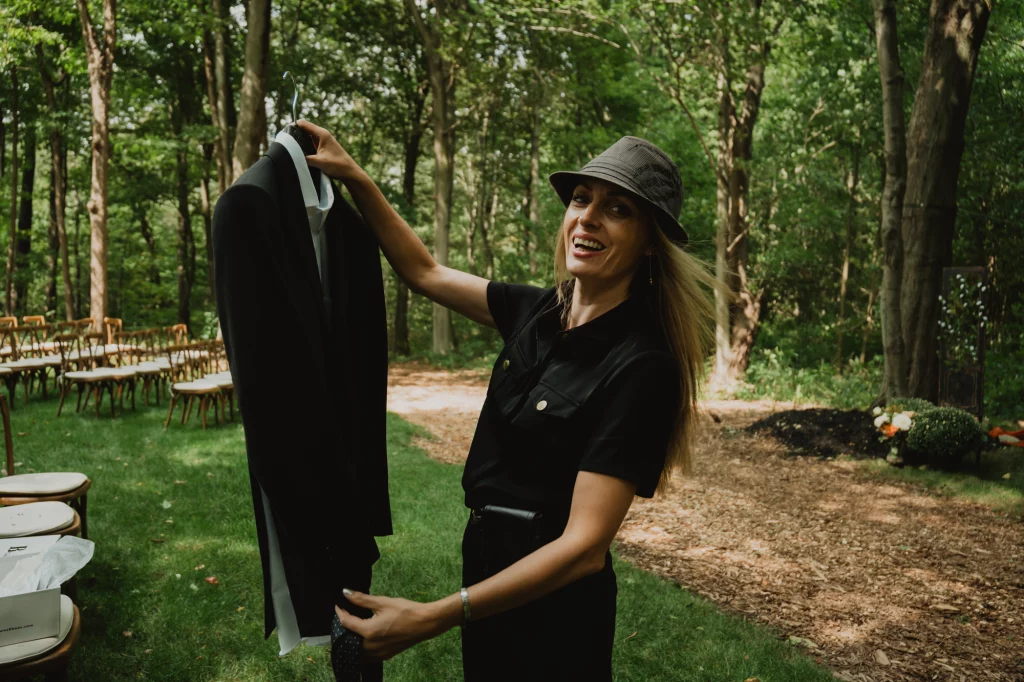Brantford wedding photographer fixing groom’s suit to take a picture of it on a wedding day