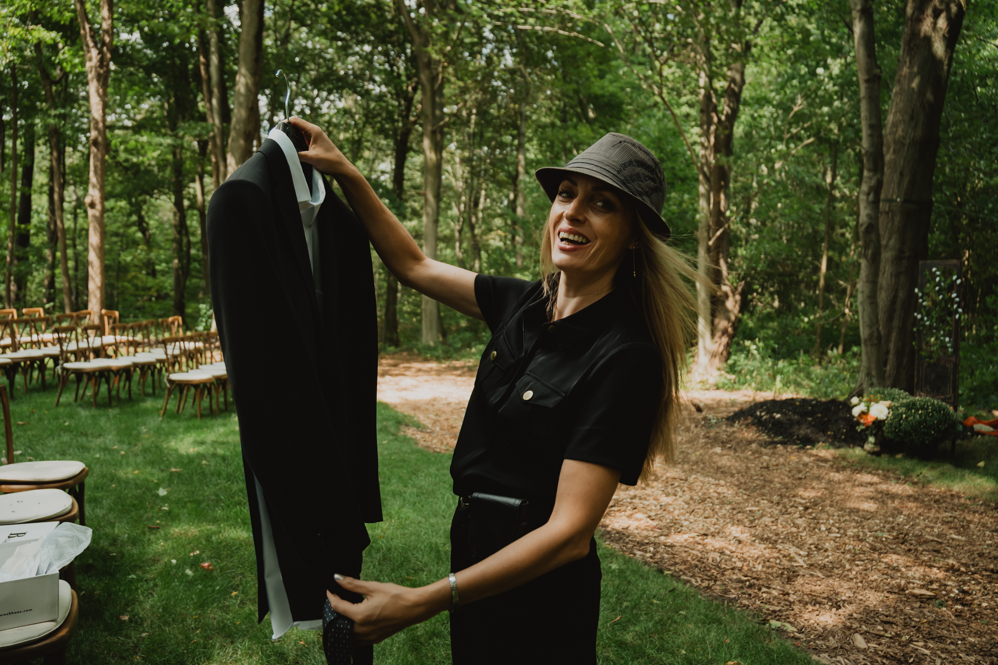 Brantford wedding photographer fixing groom’s suit to take a picture of it on a wedding day