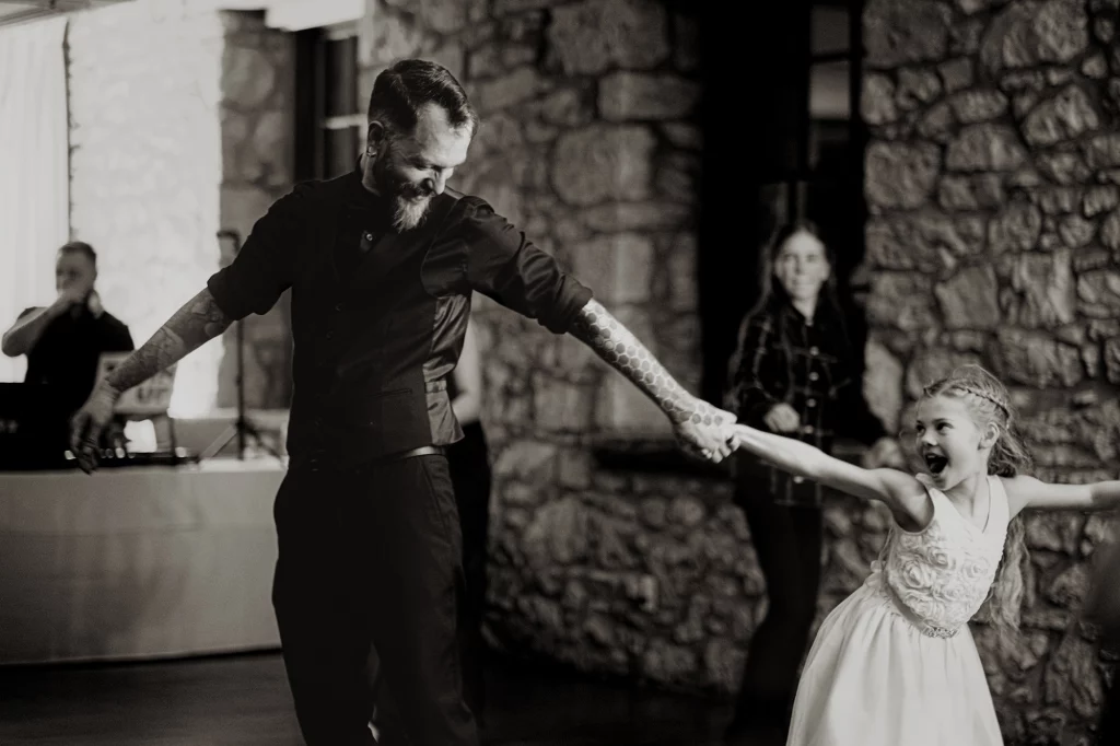 black and white photo during wedding dance party, where groom is dancing with hes niece