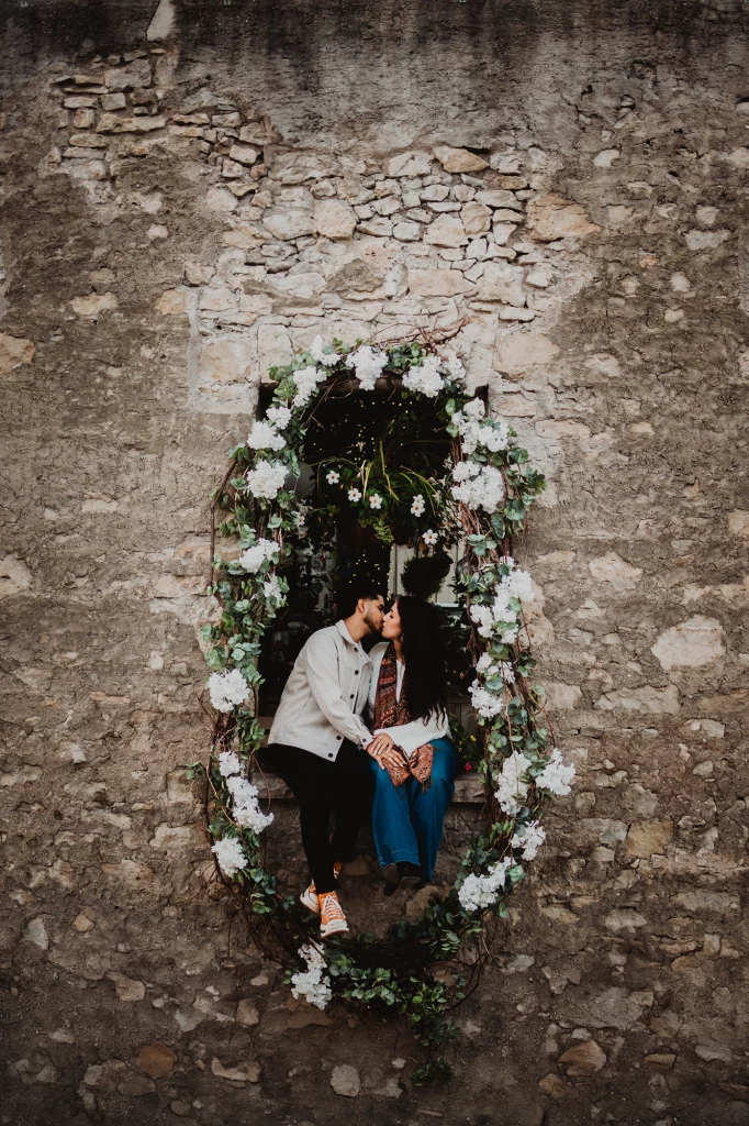 Couple kissing in a stone ruin window in Elora Downtown – photoshoot locations in Southern Ontario